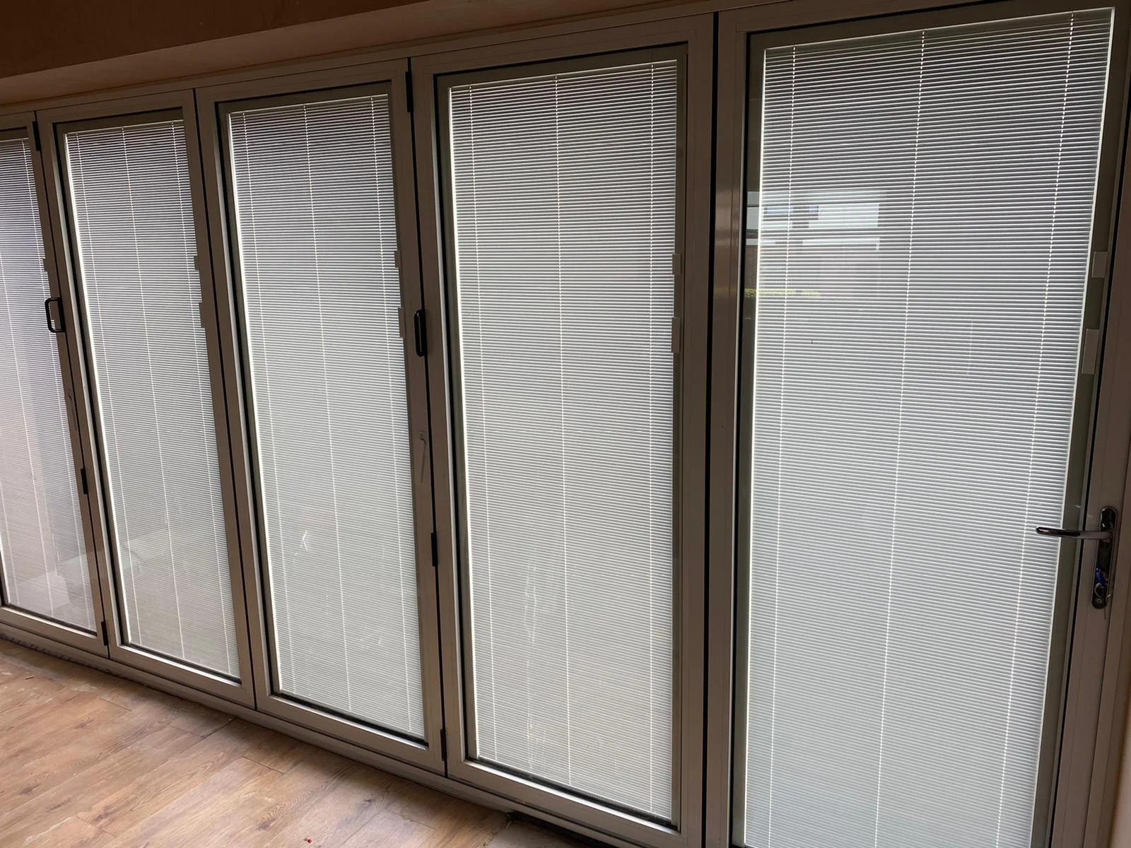 White internal bi-fold doors with integral blinds sealed inside the glass units